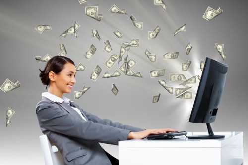 Заработанные доллары вылетают из монитора навстречу девушке