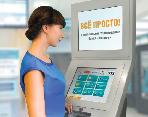 Девушка стоит у платёжного терминала